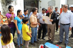 El alcalde de Chone observa muy detenidamente el poster que recibio por los deportistas participantes en el evento.