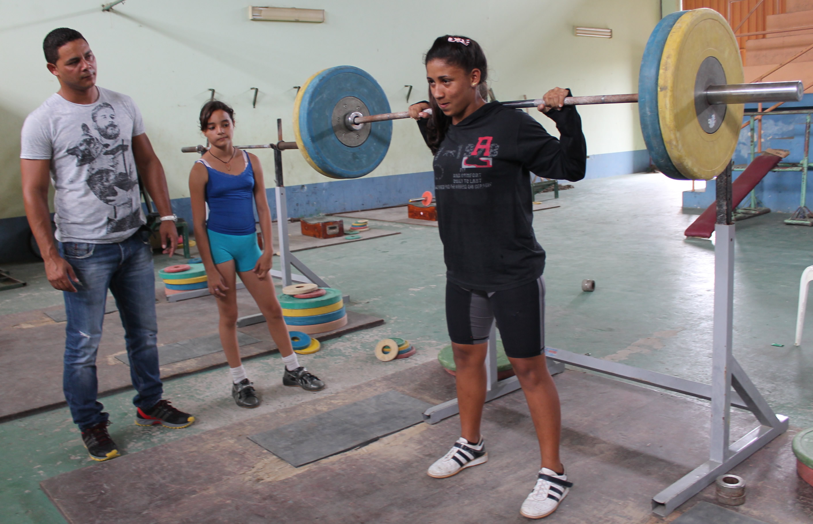 Yohandris HernÃ¡ndez (i) dirige el entrenamiento de de la pesista Karol Douglas