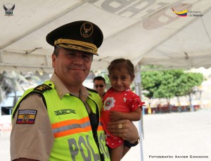 Mauro Vargas, jefe del Distrito Manta, junto a una pequeña con síndrome de Laron en la playa El Murciélago