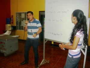 Momento en que los estudiantes enseñaban inglés a los taxistas, la estudiante - maestra pone la muestra en la pizarra